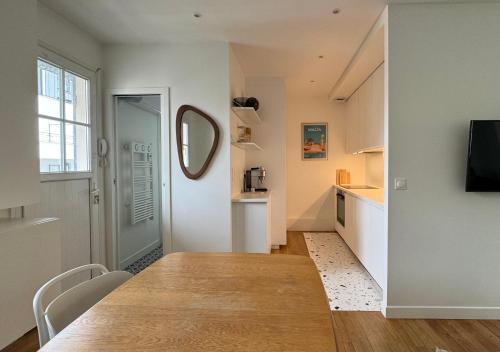 - un salon avec une table et un miroir dans l'établissement Appartement 2 pièces avec balcon, à Issy-les-Moulineaux