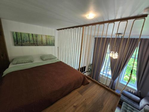 a bedroom with a bed and a large window at Loft Apartment in Klaipėda