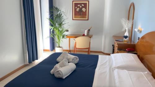 1 dormitorio con 1 cama con toallas en BAJAMAR BEACH HOTEL en Formia