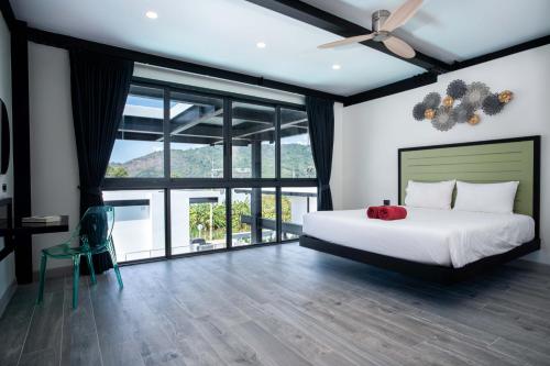 a bedroom with a bed and a large window at LUXURY 4BR Oxygen Pool Villa Near Nai Harn Beach - Sunset Garden 7 in Rawai Beach