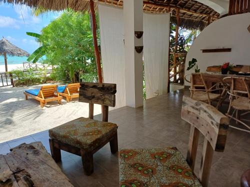 a room with a table and chairs and a view of the beach at Namayani apartment in Pwani Mchangani