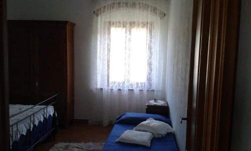 a bedroom with a bed and a window at B&B Poderone in Querceto