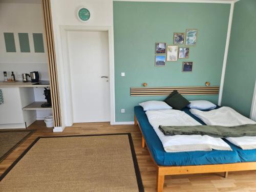 a bedroom with a bed with blue walls and a mirror at Fewo Schwäbische Eisenbahn in Meckenbeuren