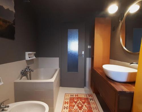 a bathroom with a sink and a tub and a toilet at Maison à la coque in Baceno