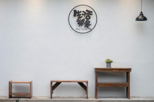 Guangrong的住宿－生活就是壽豐Villa民宿，白色墙上的两张桌子和一个钟