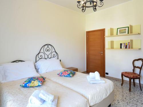a bedroom with two beds with towels and a chair at La Piccola Bellagio in Bellagio