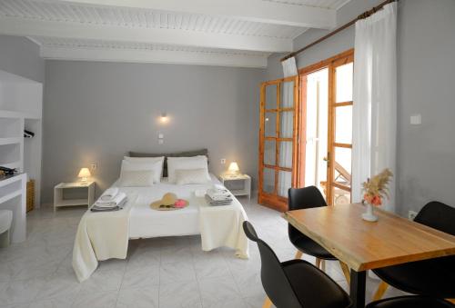 - une chambre avec un lit blanc, une table et des chaises dans l'établissement Albouro Seafront Apartments, à Kateliós