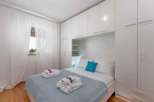 a white bedroom with towels on a bed at Apartment in Dramalj 5715 in Dramalj