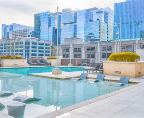 a swimming pool with chairs and buildings in the background at Modern Midtown Oasis in Atlanta