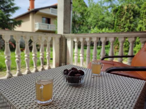 einen Tisch mit einer Obstschale und zwei Getränken auf dem Balkon in der Unterkunft Sarajevo Paradise in Sarajevo