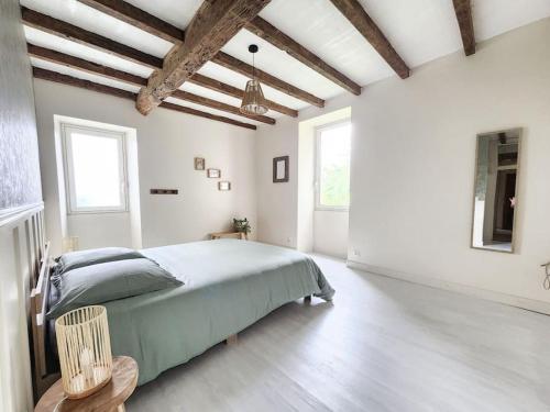 une chambre blanche avec un lit et deux fenêtres dans l'établissement Maison de Campagne, à Beaugas