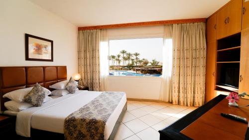 a bedroom with a large bed and a window at Kefi Palmera Beach Resort El Sokhna - Family Only in Ain Sokhna