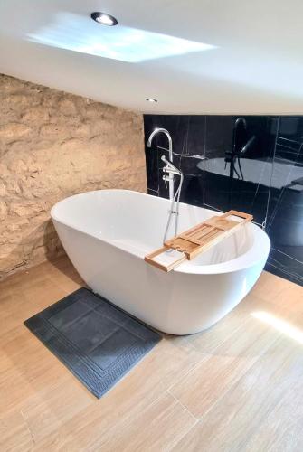 La salle de bains est pourvue d'une baignoire blanche. dans l'établissement ! New Prestige Loft climatisé terrasse jacuzzi !, à Pont-à-Mousson