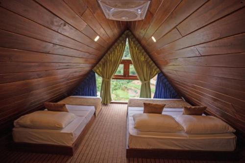 Zimmer mit 2 Betten in einem Holzzimmer in der Unterkunft Wenasa Holiday Resort in Diyatalawa