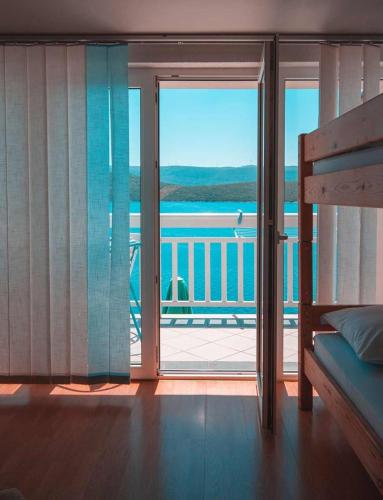 a bedroom with a balcony with a view of the ocean at Villa Raguž sa Privatnom plažom i Garažom in Neum