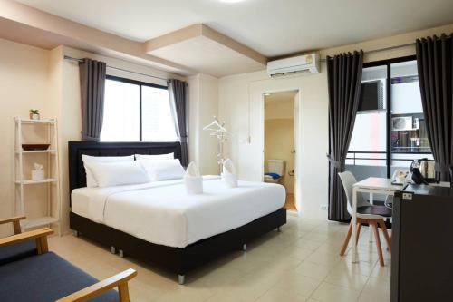 1 dormitorio con 1 cama y escritorio con ordenador en Bansuay Phranangklao Apartment&Hotel en Ban Sai Ma