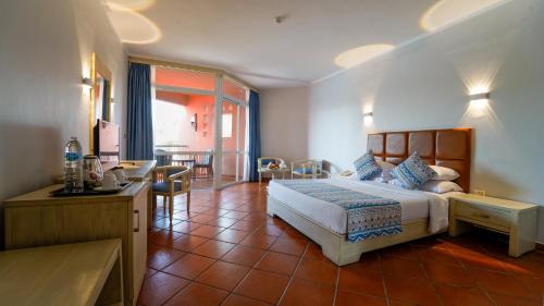 1 dormitorio con 1 cama, mesa y sillas en Kefi Palmera Beach Resort El Sokhna - Family Only, en Ain Sokhna