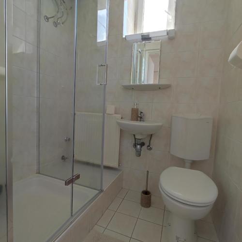 a bathroom with a toilet and a shower and a sink at Villa Vanília in Keszthely