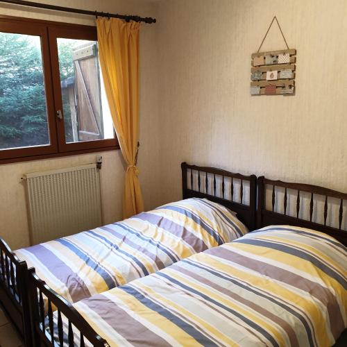 une chambre avec un lit et une fenêtre dans l'établissement Maison vosgienne proche de la Bresse et Gerardmer, à Basse-sur-le-Rupt