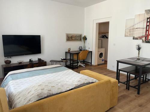 un salon avec un lit et une télévision à écran plat dans l'établissement L’industriel, à Montréjeau