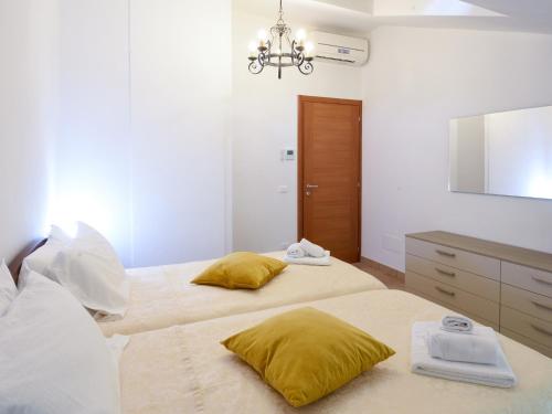 two beds with yellow pillows in a bedroom at La Piccola Bellagio in Bellagio