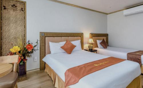 una habitación de hotel con 2 camas y una silla en Pearly Hotel en Jeju