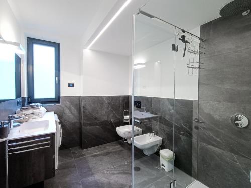 uma casa de banho com um chuveiro, um WC e um lavatório. em Suite Svaizer con giardino privato em Malè