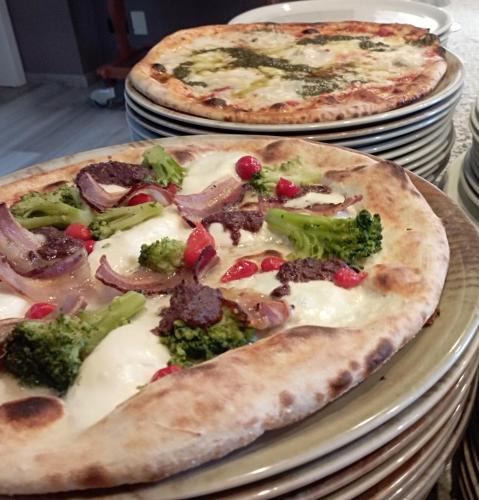 two pizzas sitting on top of plates on a table at Hotel Paradiso in Sarnonico
