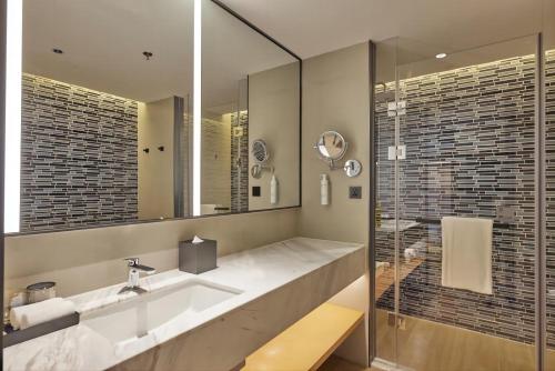 a bathroom with a sink and a mirror at Fairfield by Marriott Guangzhou Konggang in Guangzhou