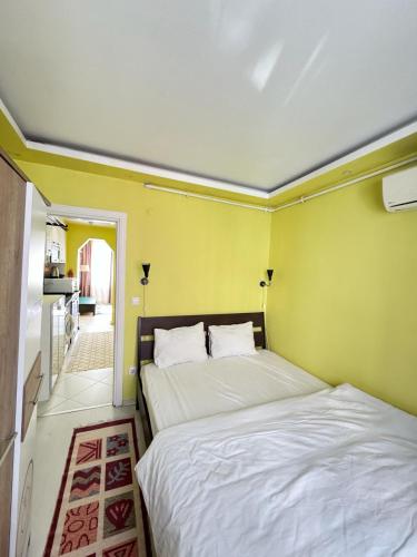 two beds in a room with yellow walls at Plaesant apartment with Balcony in Istanbul