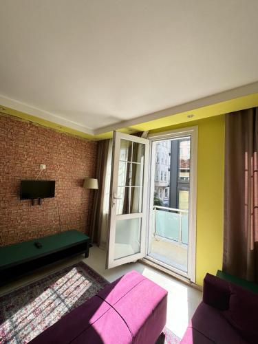 a living room with a couch and a large window at Plaesant apartment with Balcony in Istanbul