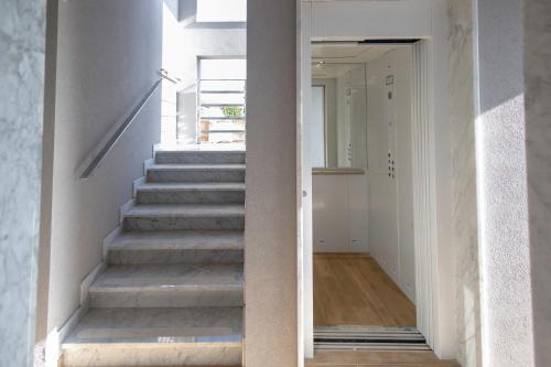 a staircase in a home with white walls and concrete stairs at Elysium B&B in Mazara del Vallo
