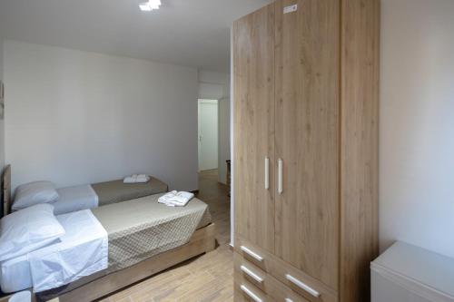 a bedroom with a bed and a wooden cabinet at Elysium B&B in Mazara del Vallo
