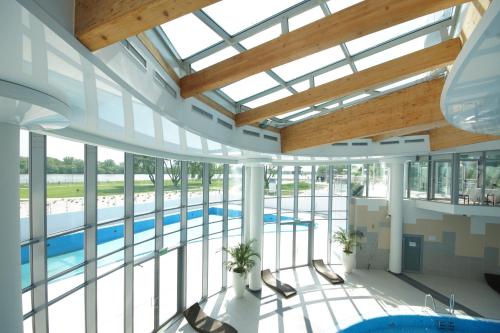 a large building with a pool and windows at Copernicus Toruń Hotel in Toruń