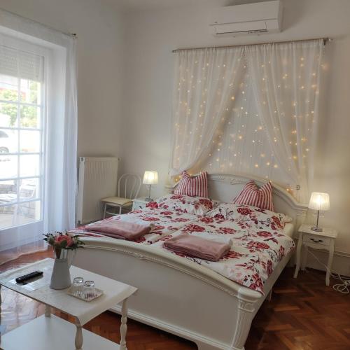 a bedroom with a large white bed with a canopy at Villa Vanília in Keszthely