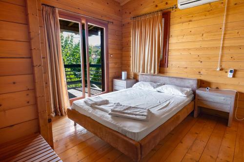 a bedroom with a bed in a wooden cabin at Zeus-Village οικισμός φινλανδικών chalet με πισίνες & γυμναστήριο in Mólos