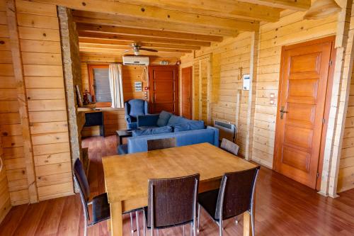 a dining room with a blue couch and a table at Zeus-Village οικισμός φινλανδικών chalet με πισίνες & γυμναστήριο in Mólos