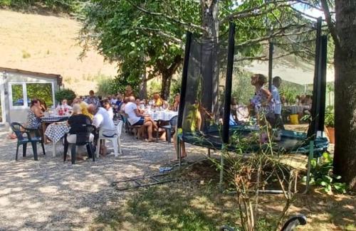 a group of people sitting at tables in a garden at Ala di Maniero in Agriturismo Valdrago in Toscana, nel Verde Mugello sulle Colline di Firenze Autodromo Mugello Circuit in Borgo San Lorenzo