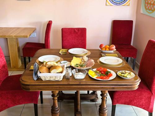 a wooden table with food on it with red chairs at Willa Ogrodnika in Błażowa