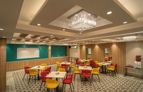 a dining room with tables and chairs and a projection screen at Sparrow Hotel Managed by Siara Sariska Alwar in Alwar