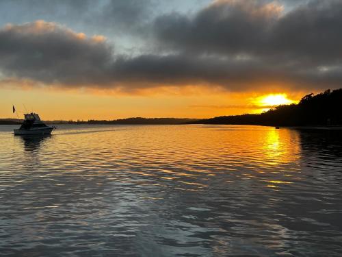 a boat in the water with the sunset in the background at Island Leisure Village in Bobs Farm