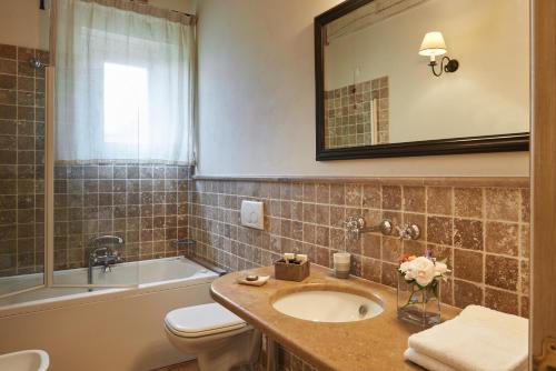 a bathroom with a sink and a tub and a toilet at Pamperduto Country Resort in Porto Potenza Picena
