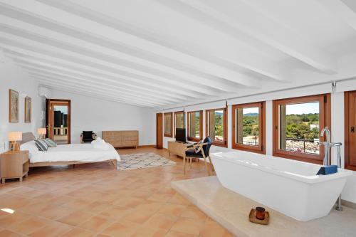 a bedroom with a bathtub and a bed and a bed and a television at LA CITA DEL MAR Cala Marsal Luxury SEA experience in Portocolom