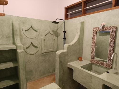 een badkamer met een wastafel en een spiegel bij Mgongo tree house in Jambiani