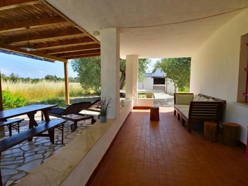 a patio with benches and a table and chairs at Dommos - Casa Sicutera in Orosei
