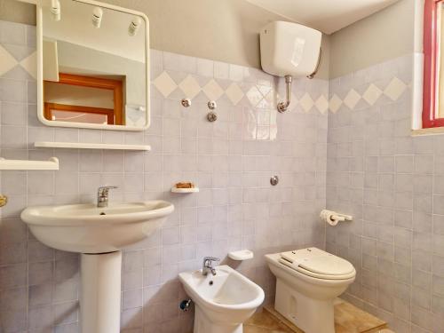 a bathroom with a sink and a toilet and a mirror at Casa Sicutera - Villetta indipendente situata a 4 chilometri dalla spiaggia di Su Petrosu in Orosei