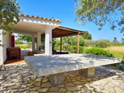 a stone bench in front of a pavilion at Casa Sicutera - Villetta indipendente situata a 4 chilometri dalla spiaggia di Su Petrosu in Orosei