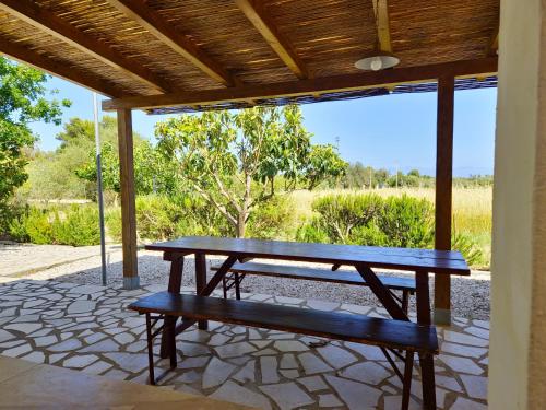 a picnic table and a bench on a patio at Casa Sicutera - Villetta indipendente situata a 4 chilometri dalla spiaggia di Su Petrosu in Orosei