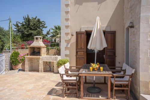 a patio with a table and an umbrella at Aloe & Lotus Villas in Prinés