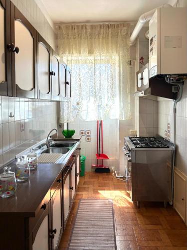 a kitchen with a sink and a stove at Appartamento TD in Follonica